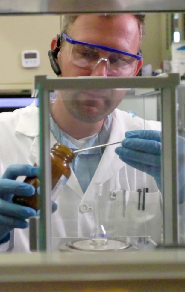 Dr. Levente Pap weighing a sample on an analytical balance in the laboratory